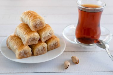 Geleneksel Türk hamur işleri, Türk çayı ve şam fıstığı ile ahşap bir yüzeyde tatlı baklava tatlısı..