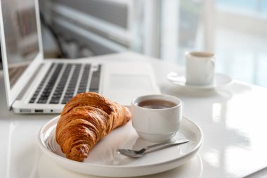 Kahve molası. Kahvaltı ya da iş yerinde öğle yemeği. Masaüstü ofiste. Not defteri, kruvasan, kaşık, reçel ve kahve fincanı..