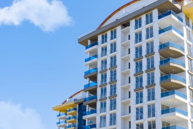 Sarı ve mavi modern pencereli havalandırmalı cephe. Yeni bir konut ya da ticari kompleksin parçası. Şehrin gayrimenkulleri.