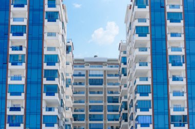 Pencere balkonları mavi ve beyaza boyanmış çok ailelik bir apartman kompleksinin soyut görüntüsü. arkaplan mimarisi.