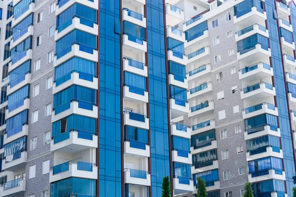 Abstract view of a multi-family residential complex of condominiums with window balconies painted in blue and white. background architecture.