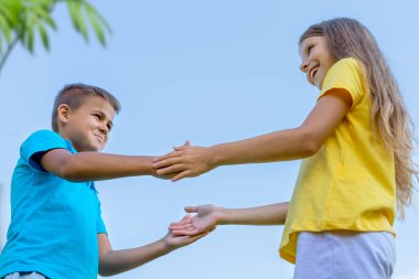 İki çocuk, bir oğlan ve bir kız, gökyüzüne karşı oynuyorlar. Çocukların arkadaşlığı..