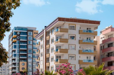 Yeşillik ve çiçekler arasında yerleşim binaları manzaralı kentsel Türk manzarası.