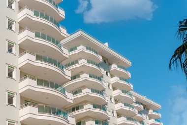 Apartman binası ve ev cephesi mimarisi ve açık hava objeleri. Arka planda mavi gökyüzü.