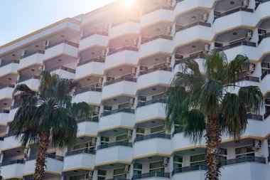 Identical semicircular balconies on the facade of a building in southern Turkey. Part of a hotel or apartment house against the sky.