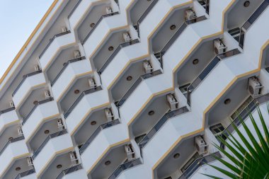 Identical semicircular balconies on the facade of a building in southern Turkey. Part of a hotel or apartment house against the sky.