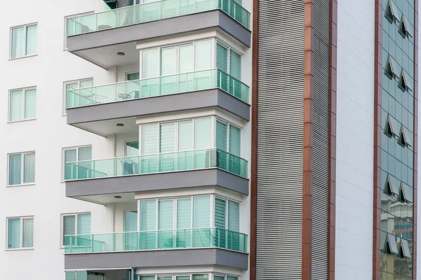 Fragment of a residential building with windows and balconies. Architectural background.
