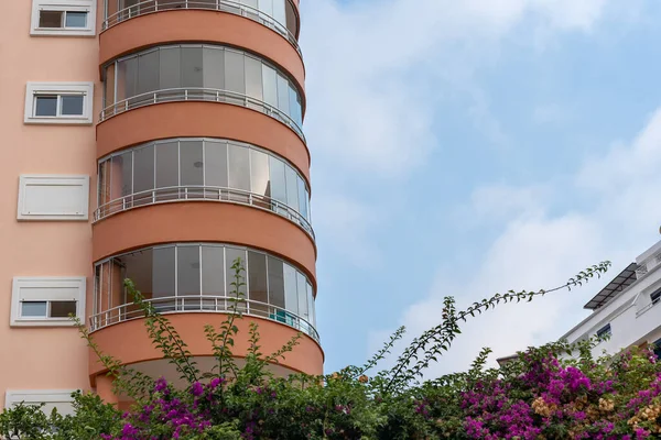 Orange residential building with round balconies against the sky. Copy space.