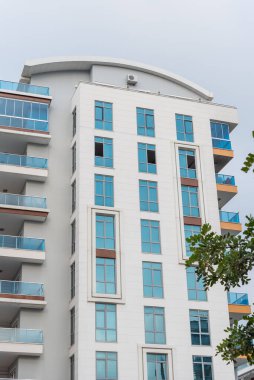Modern tall residential apartment building with French windows. Vertical shot.