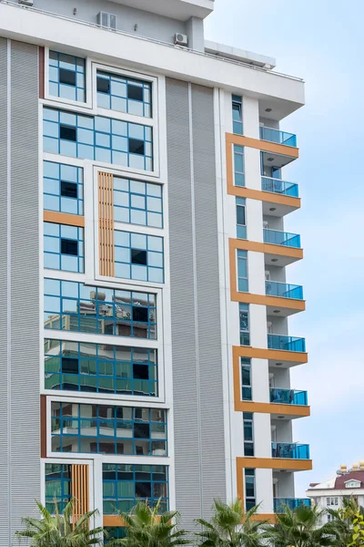 Tall residential apartment building with a glass facade. Vertical shot.