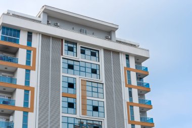 Tall residential apartment building with a glass facade. Horizontal shot.