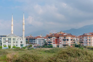 Alanya, Turkey - August, 2022: Scenic view of the mosque against the backdrop of a residential area in Alanya.