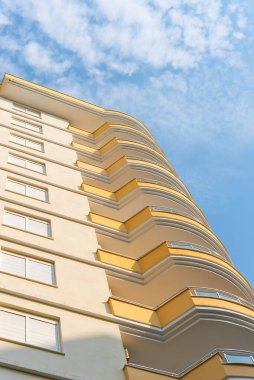 Low angle view of an apartment building with balconies. Residential real estate.