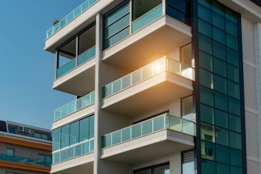 Image of the exterior of a residential building against a blue sky. Residential real estate in Turkey.