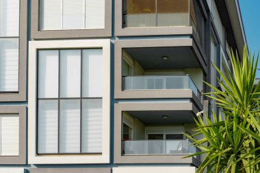 Image of the exterior of a residential building against a blue sky. Residential real estate in Turkey.