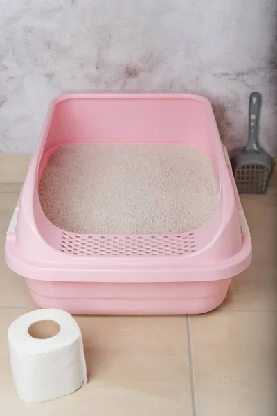 Clumping cat litter in the litter box in the restroom.