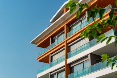 Image of the exterior of a residential building against a blue sky. Residential real estate in Turkey.