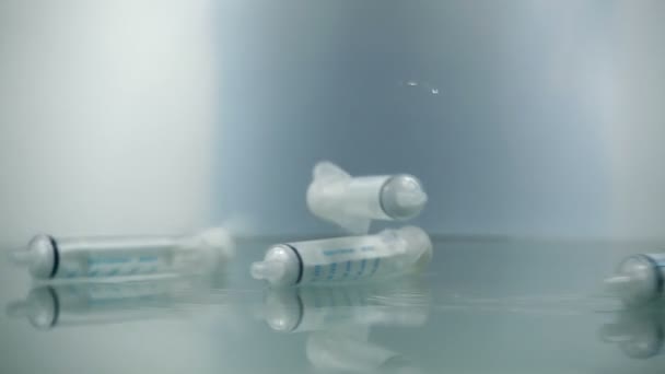 注射器以慢动作降落在蓝色的背景上 药物针头针头注射器流感注射疫苗静脉滴注皮下注射疗法预防疾病免疫 — 图库视频影像