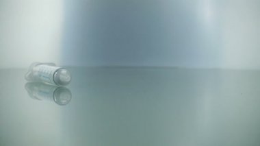 Şırıngalar yavaş çekimde mavi arka plana düşüyor. İlaç iğnesi şırıngası grip aşısı Vial Dose Hipodermik Enjeksiyon Tedavisi Hastalığı İmmün Önleme