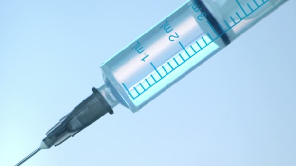 注射器蓝色背景下注射液的近视 药物针头针头注射器流感注射疫苗静脉滴注皮下注射疗法预防疾病免疫 — 图库视频影像