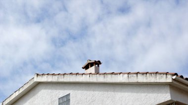 Gökyüzüne karşı şömineli bir çatı.