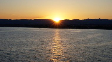 Dağlar arasında, denizin üzerinde güneş ışınları