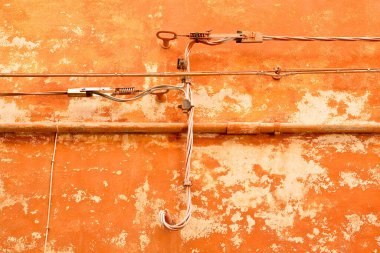 Elektrik kabloları ve telefon kabloları elektrik dağıtımı için eski bir tuğla ve alçı duvara karşı. 