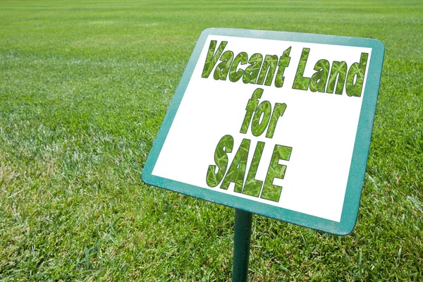 Advertising signboard with Vacant Land for Sale written on it against a green meadow - concept image.