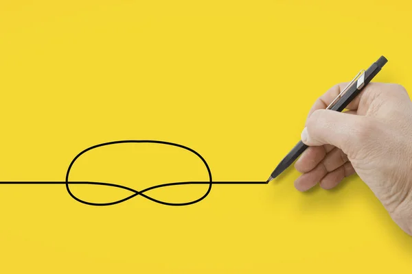 Elinde Siyah Bir Kalem Sarı Arka Planda Bir Düğüm Çiziyor — Stok fotoğraf