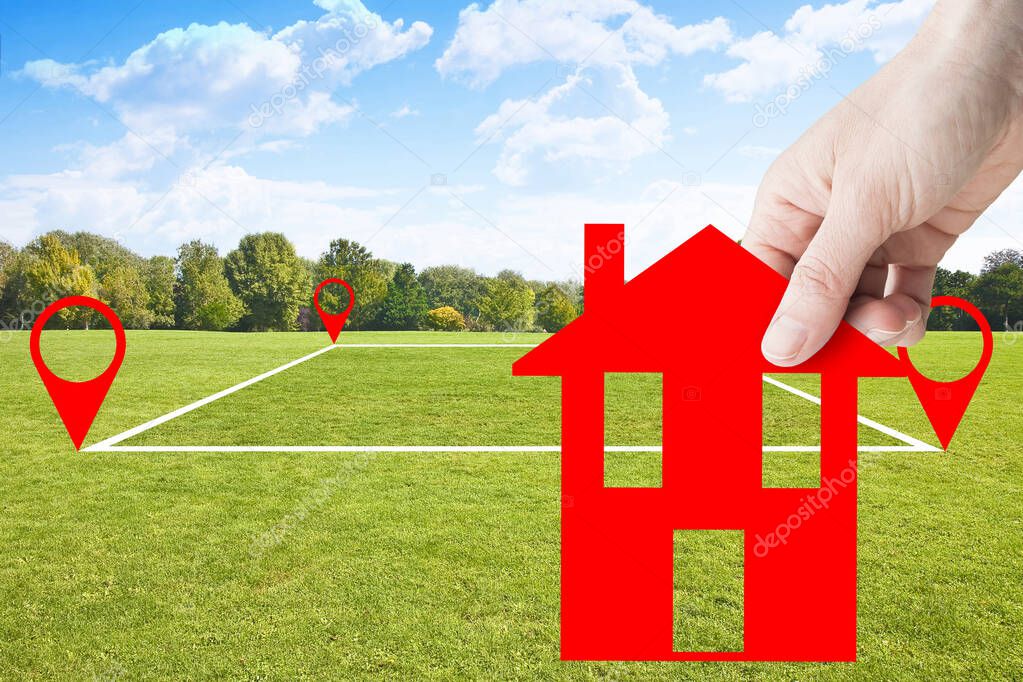 Land plot management - real estate concept with a vacant land parcel available for building construction - housing concept with hand holding a little red house in a residential area for sale