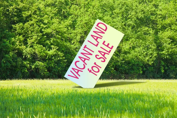 Advertising billboard in a rural scene with Vacant Land for Sale written on it - Real Estate concept image