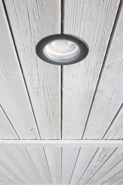 Modern metal spot ışığı dairesel şekilli lambayı ahşap bir tavana yerleştirdi.