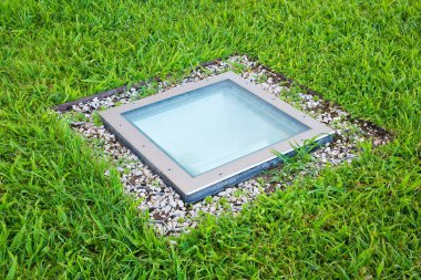 Modern dörtgensel metal spot lambası açık havada kullanmak için yeşil zeminde kare şeklini almış. 