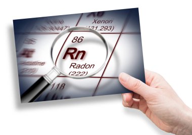 Radon gazı tehlikesi - elementlerin periyodik tablosu ve büyüteç ve bir kartpostal tutan el konsepti