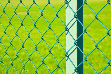 Yeşil metal tel halka açık bir parkın yeşil bir alanına ya da özel bir mülke bağlı..