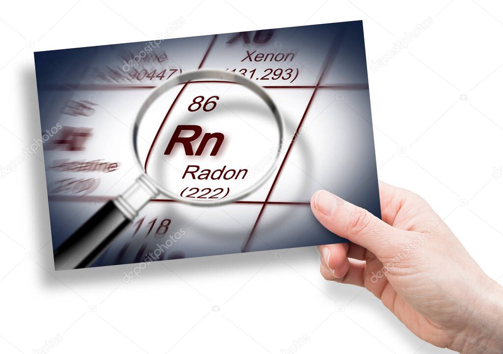 The danger of radon gas - concept with periodic table of the elements and magnifying lens and hand holding an postcard