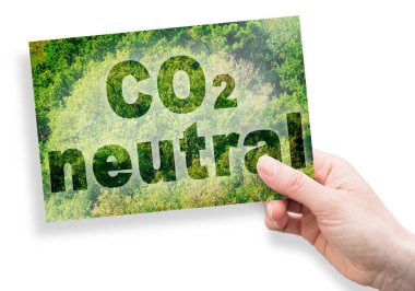 CO2 nötr metin - bir orman arka planı karşı kavram ve bir kartpostal tutan el