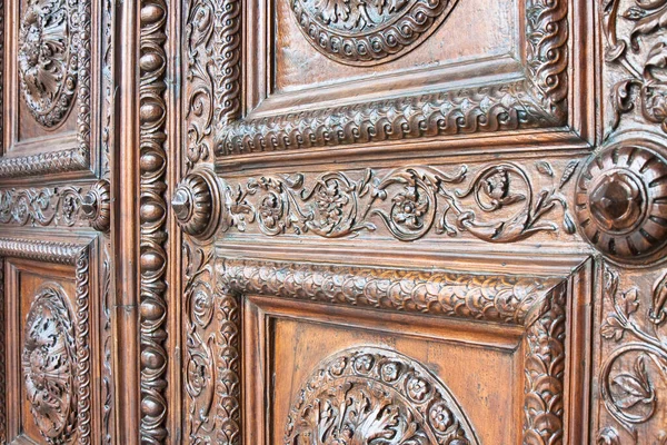 Detail of an old italian wooden carved door with floral decorations - Cathedral of St. Martin (Italy-Tuscany-Lucca city)