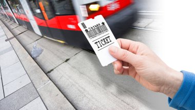 Hand holds a city tram ticket - payment concept with bus that is coming - Bar code and code numbers are completely made up