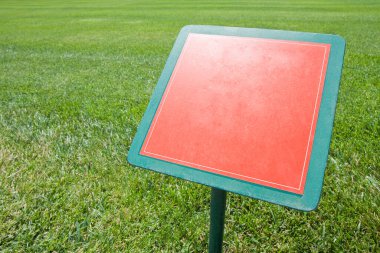 Blank advertising signboard in a green mowed lawn - concept image with copy space.