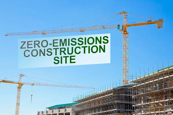 Zero-Emissions and Carbon Neutrality in building activity and construction industry - concept with text and tower crane in a construction site