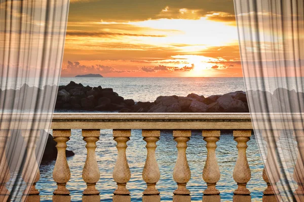 Italian balustrade against a calm sea at sunset  - indoor concept image with curtains