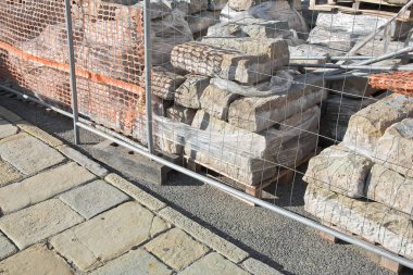 Pile of old sandstone slabs ready to be mounted in a new pavement in a urban construction site