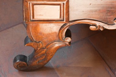 Çiçekli ve klasik elementlerle işlenmiş eski bir İtalyan ahşap mobilyasının ayrıntıları.