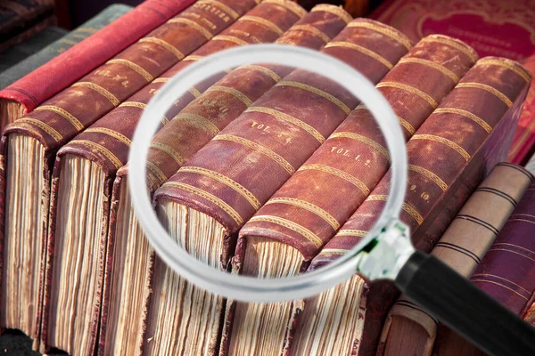 Old books in the flea market - every visible brand has been removed - Concept image seen through a magnifying glass.