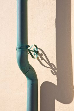 Paslı bakır borular, gölgeli sıva duvarlara karşı.