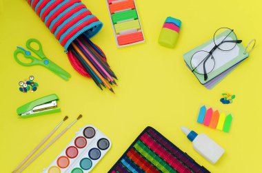 Okula dönelim. Okul malzemeleri: makas, kırtasiye düğmeleri, zımba, fırça, boya, defter, yapıştırıcı, öğütücü, gözlük, Rubik küpü, not defteri, kalem kutusu, yer imleri, kalemler, parlak renkler.