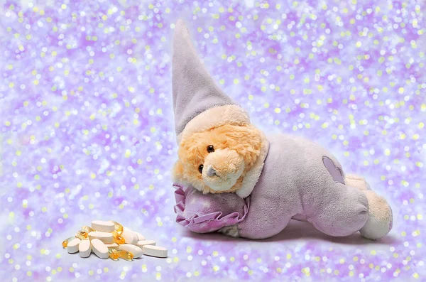 A vivid photo of a soft toy,a bear in a sleep cap trying to fall asleep.Soft toy sleeping.Concept: insomnia for children,insomnia pills,fight against insomnia.World sleep day.Very peri.Color 2022