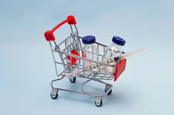 Een Blauwe Achtergrond Een Supermarkt Trolley Gevuld Met Een Vaccin — Stockfoto