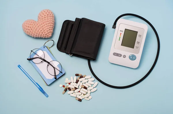 Tonometer, heart, pressure tracking records, glasses, notebook, pen, health diary.Blood pressure and heart rate measurement diary.Cardio log.Tablets for hypotension and hypertension.